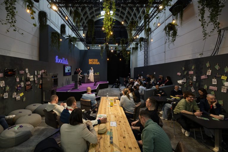 Ein Event mit Publikum in einem modernen Raum mit Pflanzen und Präsentation.